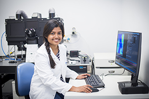 Photo of a female researcher at a microscope